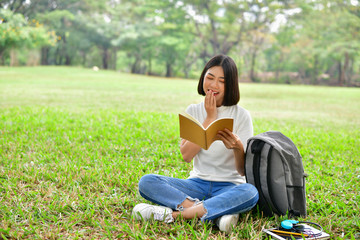 Naklejka na ściany i meble Education Concepts. Asian women reading books in the park. Beautiful women are relaxing in the park. Beautiful women are happy to read.