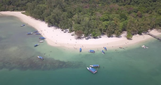 The shores of Pulau Beras Basah island with tourists and boats. Aerial shot.