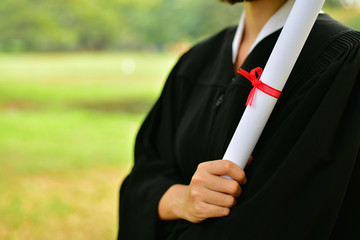 Graduation Concept. Graduated students on graduation day. Asian students are smiling happily on the graduation day. Students wear graduation gowns in the garden