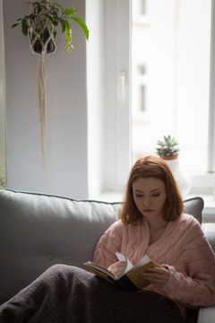 Woman flipping pages of book at home