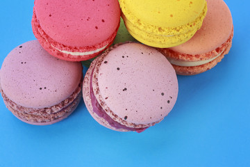 Sweet and colorful French macarons on blue background