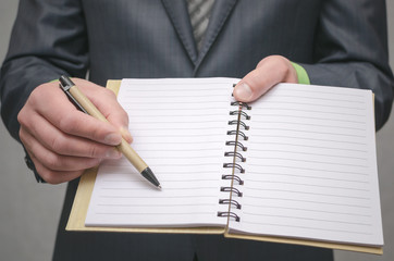 Businessman holds in hand a note pad with pen. To do list template. Goals or business tricks. Business tips concept. Task Manager.concept. Special offer..