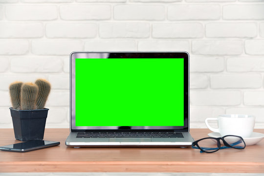 Mockup image of laptop with blank green screen.