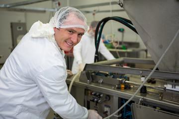 Butcher operating machine at meat factory