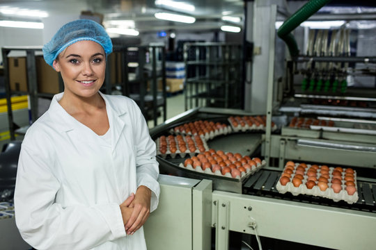 Female staff standing next to conveyor belt