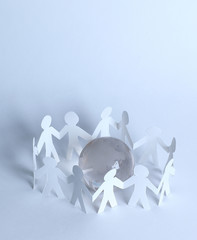 team paper men standing around the glass globe.