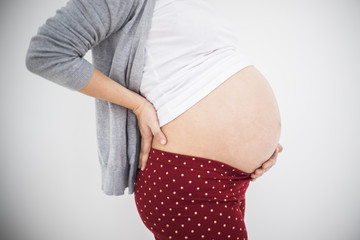 Pregnant woman touching back and feeling pain