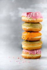 Sweet and colourful doughnuts on grey background. Fresh baked donuts. Copy space.