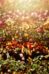 Close up tea background: green, black, floral, herbal, mint, melissa, ginger, apple, rose, lime tree, fruits, orange, hibiscus, raspberry, cornflower, cranberry. Assortment of dry tea, top view