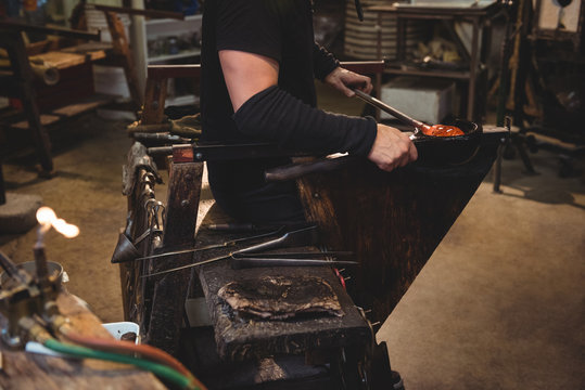 Glassblower forming and shaping a molten glass