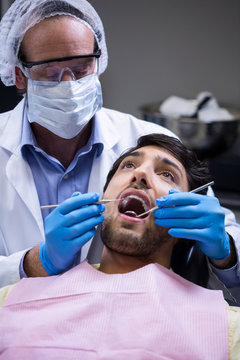  Dentist examining a patient with tools 