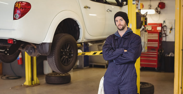 Mechanic standing with arms crossed in repair garage