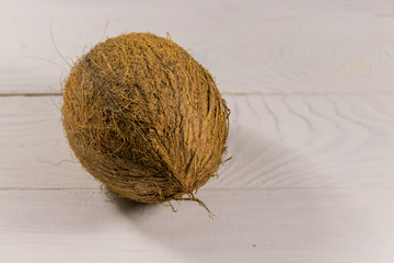 Whole coconut on white wooden table