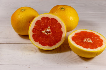 Ripe fresh grapefruits on white wooden table