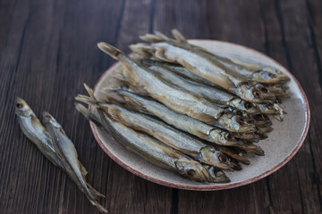 Capelin smoked on brown wooden table.