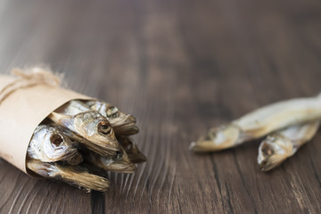 Capelin smoked on brown wooden table.