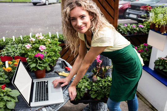 Florist Using Laptop In Garden Centre