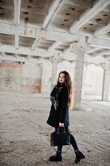 Brunette stylish casual girl in scarf and handbag against abandoned factory place.