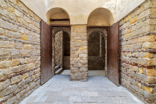 Exterior brick stone passage with two adjacent vaulted opened wooden grunge doors, Old Cairo, Egypt