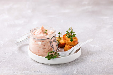 Dip from red fish in bank on a table