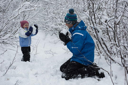 Father and daughter playing with snowballs