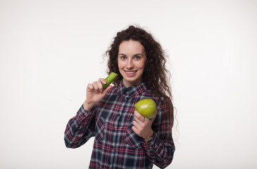 Happy young woman eating cucumber. A close-up of beautiful girl eating cucumber. Healthy smile with white teeth. Vegetarian menu and diet concept. Woman with apples