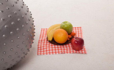 Fresh fruits isolated on white background and fit ball near. Diet and fitness concept.