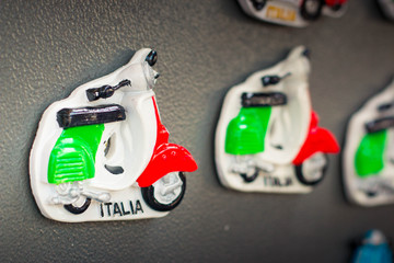 Close up of a magnet souvenir representing the typical italian vespa motocycle, with italian flag...