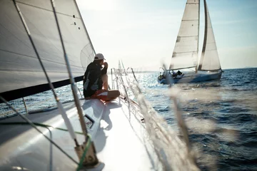 Rolgordijnen Young handsome man relaxing on his sailboat © NDABCREATIVITY