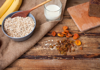 Food. Oatmeal on the table. Dry rolled oat flakes oatmeal in brown bowl on old wooden table.