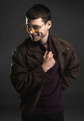 Portrait of cheerful man hiding hand. He isolated on black background. Gladness concept