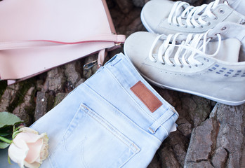 White woman sneakers with blue jeans on woman background. 