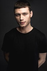 Portrait of focused young man isolated on black background. Concentration concept