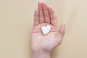 手のひらに乗せたハート型のサンゴ石