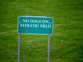 "No dogs on athletic field" sign in park