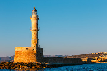 Fototapeta na wymiar view of the entrance to Chania harbor with lighthouse at sunset, Crete, Greece