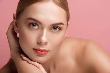 Portrait of beautiful girl having well cared skin. She is staring with calmness. Isolated on rose background