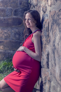 Pregnant woman leaning on wall