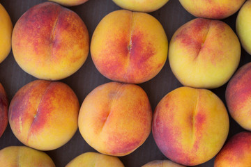 ripe peaches lie in rows in a box, closeup in detail