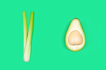 Creative layout made of celery and avocado on green background. Vegetables concept