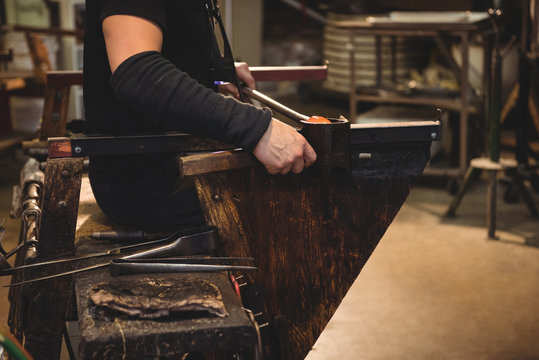 Glassblower forming and shaping a molten glass