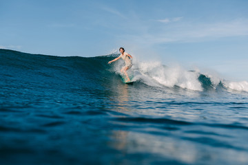 sportsman riding waves on surfboard while having vacation