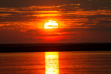 The solar disk falls over the horizon line.