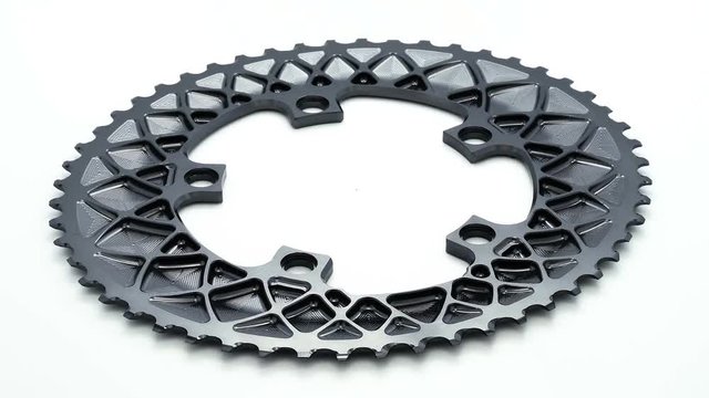 Silver oval bicycle chainring gear rotating at white background