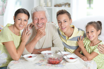 Big happy family eating fresh strawberries at kitchen