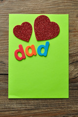 The word dad on a green note with two red hearts