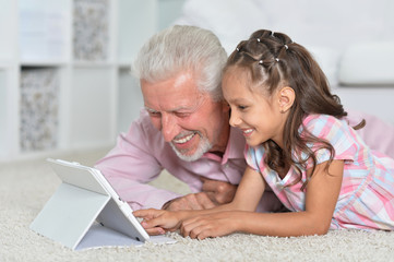 portrait of girl and grandfather with a tablet