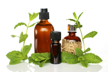 mint essential oil  set. pure mint oil in brown glass bottles and fresh mint on white background with reflection