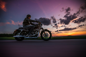 Obraz na płótnie Canvas Man riding sportster motorcycle during sunset.