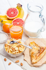 healthy breakfast. bowl of cornflakes, fruit, fresh juice, milk